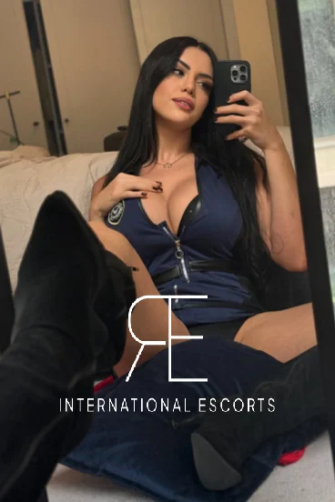 Sexy brunette TS escort Capri is sat on the floor taking a selfie 