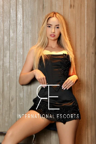 Brazilian London escort Joy is pictured wearing a black dress 