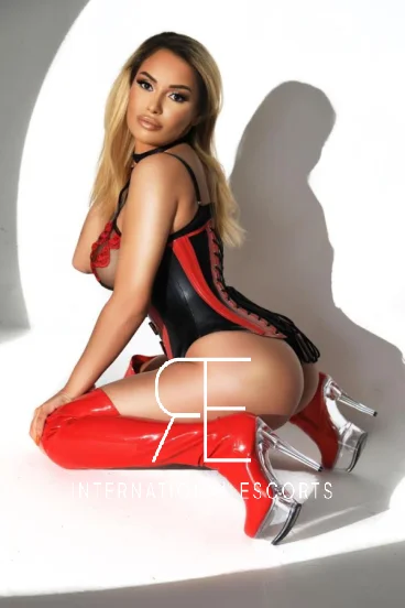 A very sexy blonde London escort named Aria is pictured on her knees 