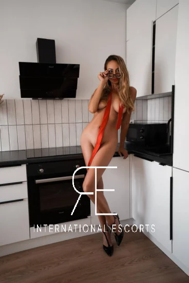 A naked London escort standing in her kitchen 