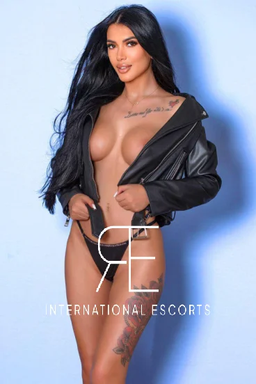 Sexy brunette London escort Trixie is wearing a leather jacket 