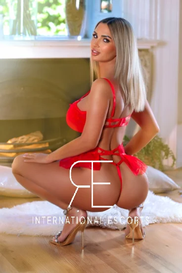 Kelly is pictured from behind wearing a red thong and very sexy gold high heels 