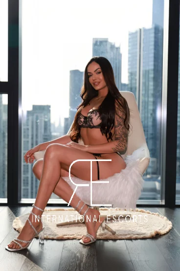 London escort wearing sexy lingerie and shoes sitting in a chair 