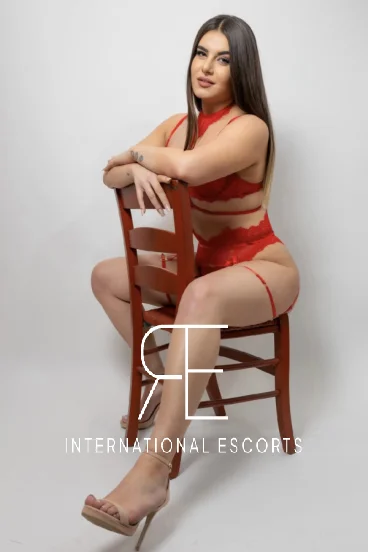 Curvy London escort Larisss is straddling a chair 