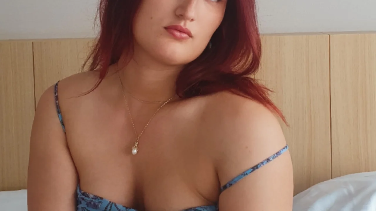 Redhead London escort wearing a blue dress 