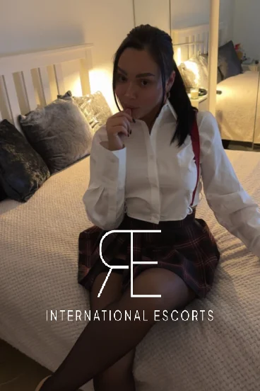 Sexy escort Julie is sitting on her bed 