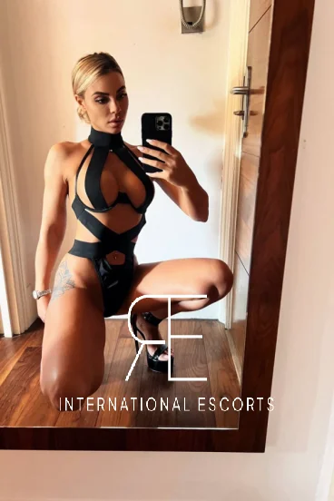 A very sexy blonde lady named Mistress Zoey is taking a selfie 