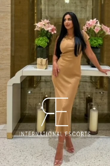 London escort wearing a sexy long gold dress and heels to show off her toes 