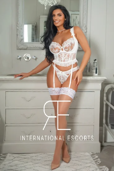 Tanned brunette escort Aylin is pictured dressed in white lace lingerie 