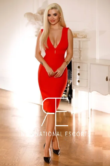 Blonde escort Hailey is wearing a red dress 