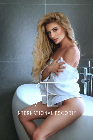 Expensive London escort Zenadia sat on the edge of a bath 